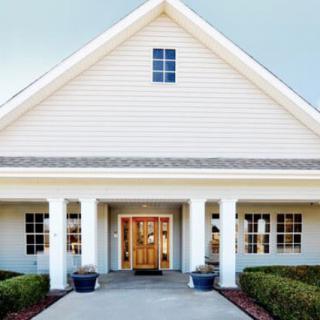 Front view of a house with a porch and symmetrical windows.