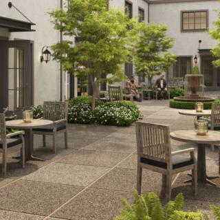 A peaceful courtyard with outdoor seating and lush greenery.