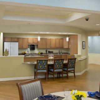 A modern kitchen and dining area with wooden cabinets and chairs.