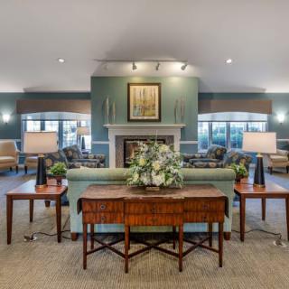 A spacious and elegantly designed living room featuring comfortable seating, a central fireplace, and tasteful decor.
