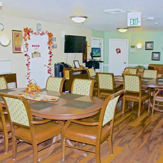 A cozy dining area with neatly arranged tables and chairs, decorated with seasonal ornaments.