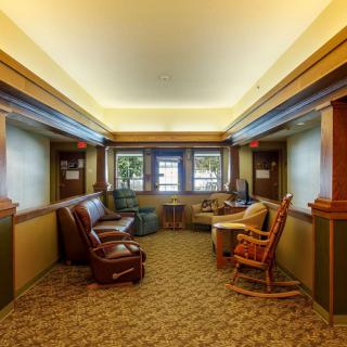 A cozy lounge area with comfortable seating and large windows.