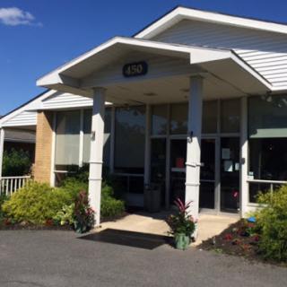 A welcoming entrance to a modern commercial building with well-kept landscaping.