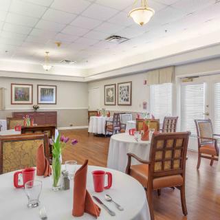 A well-appointed dining room with elegantly arranged tables and chairs, ready for guests.