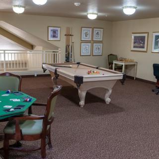 A cozy game room featuring a billiard table and seating area.