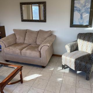 Cozy living room with a sofa, armchair, and decorative elements.