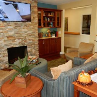 A cozy living room with a stone fireplace and wooden furnishings.
