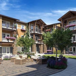 A modern apartment complex with a landscaped courtyard and outdoor seating area.