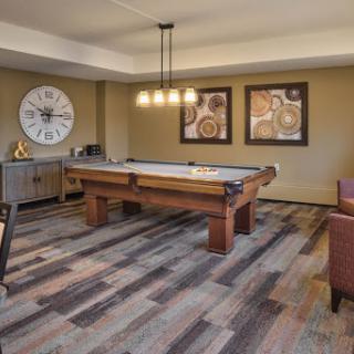 A stylish game room featuring a pool table, modern decor, and inviting seating.