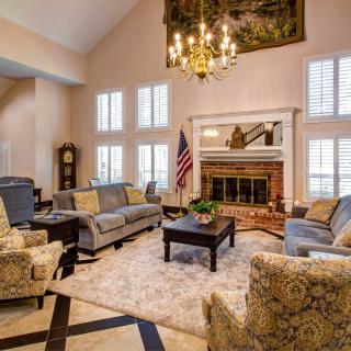 A spacious living room featuring elegant furniture, a cozy fireplace, and a decorative chandelier.