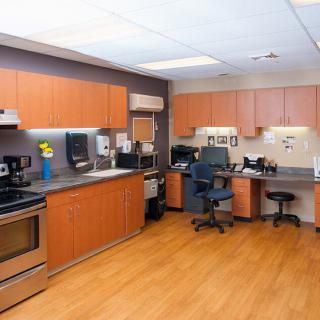 A modern office kitchen with appliances and workspace.