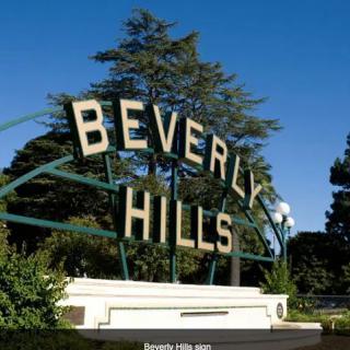 Iconic Beverly Hills sign surrounded by greenery.