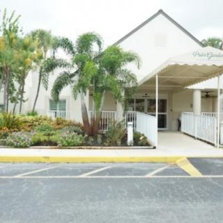 Entrance to a building with palm trees and accessible ramp.