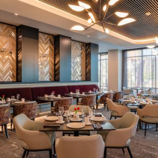 A modern restaurant interior with elegant lighting and neatly arranged seating.