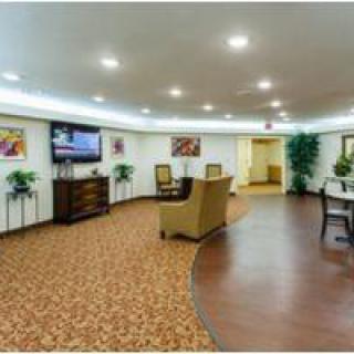 A modern lobby area featuring comfortable seating and a large television.