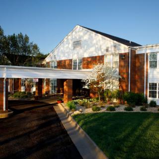 Exterior view of a building with a landscaped lawn and trees.