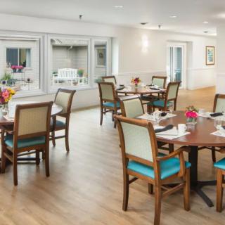 A well-lit dining area with multiple tables set for meals.