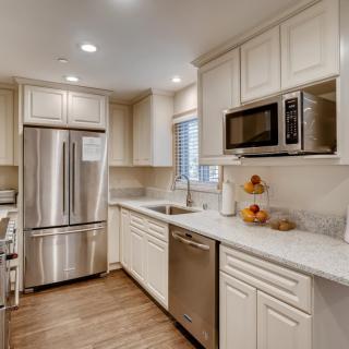 A modern kitchen featuring stainless steel appliances and white cabinetry.