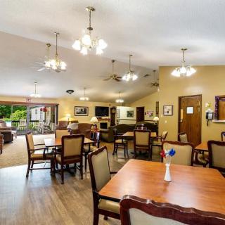 A spacious dining area with multiple tables and chairs, decorated with ceiling lights and warm colors.