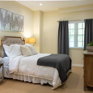 A cozy and elegantly designed bedroom featuring a comfortable bed, contemporary furnishings, and soft natural light.