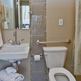 A compact bathroom featuring essential fixtures including a toilet, sink, and shower area.