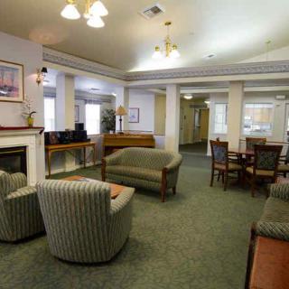 A cozy living room with sofas, chairs, and a table, featuring a warm and inviting interior decor.