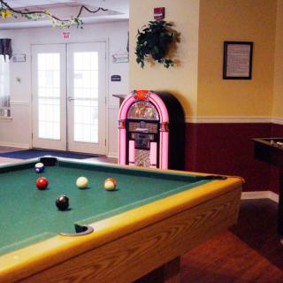 A cozy game room featuring a pool table and a classic jukebox.