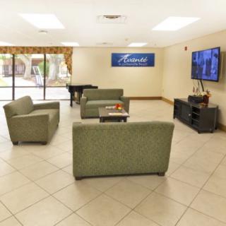 A modern lobby with comfortable seating and a large television.