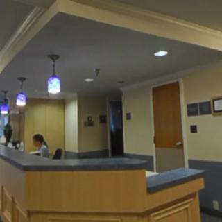A reception area with a desk and overhead lights in an office setting.