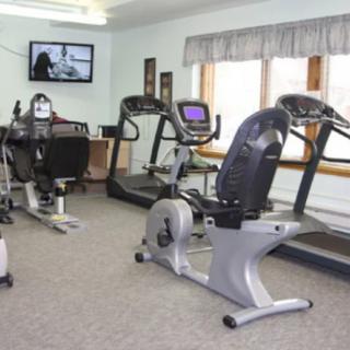 A small indoor gym featuring exercise bikes and treadmills.