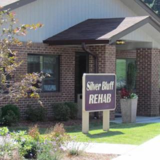 A rehabilitation center with a prominent sign in front of a brick building.