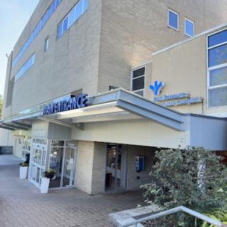 A modern hospital entrance showcasing contemporary architecture and clear signage.