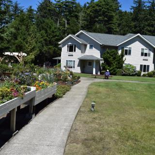 A charming house with a garden pathway surrounded by trees.