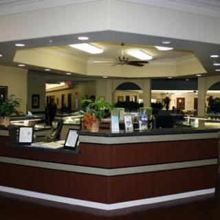 A spacious reception area with a central desk and elegant lighting.