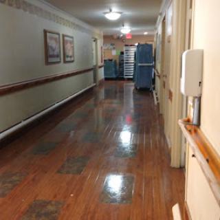 A hallway with polished floors and stacked furniture at the end.