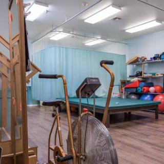 A physical therapy room equipped with exercise machines and rehabilitation tools.