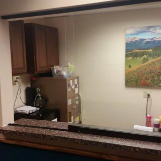 A view of an office reception area with a counter and a landscape painting on the wall.