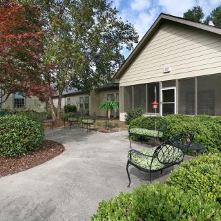 A peaceful garden with benches and a pathway leading to a building.