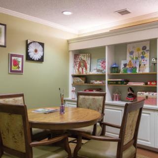 A cozy dining room with a round table, chairs, and wall art.