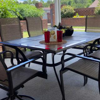 A cozy outdoor patio area with a table and chairs, perfect for relaxing and enjoying the garden view.