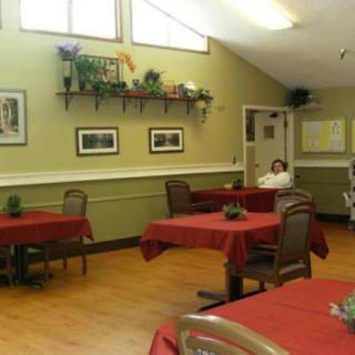 A cozy dining area with red tablecloths and wall decorations.