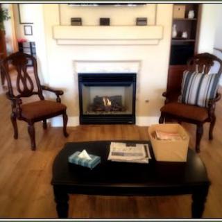 A cozy living room setup with two elegant chairs, a coffee table, and a fireplace.