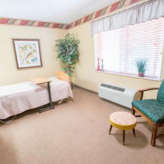 A cozy room featuring a comfortable chair, small table, and decorative elements.
