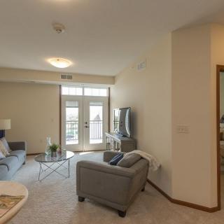 A modern living room with a sofa, TV, and large windows.