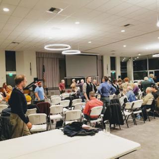 A community gathering taking place in a spacious indoor venue.
