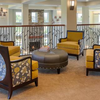A cozy and stylish living room with yellow armchairs and a central round table.