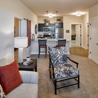 A modern open-concept living space with a view of the kitchen and stylish furniture.