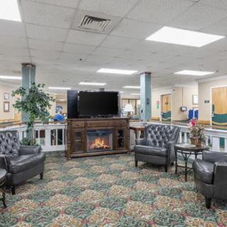 A cozy lobby with seating, fireplace, and television.