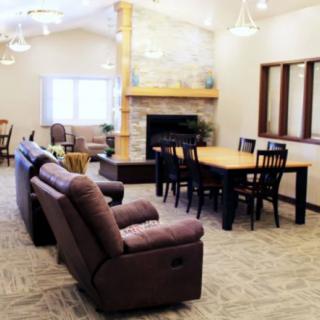 A cozy living room with a couch, dining table, and fireplace.