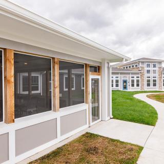 Modern building with large windows and a winding pathway under an overcast sky.